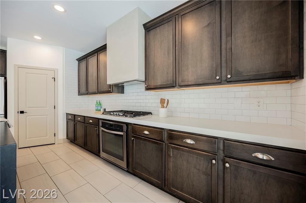 Dark wood perimeter cabinets with quartz counters and cup pulls at 2430 Quiet Ode Street