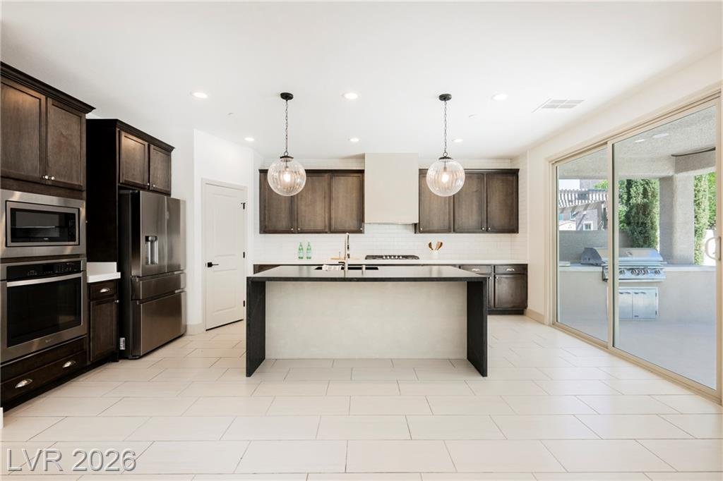 Kitchen with tall wood cabinets and sliding glass door to the outdoor kitchen