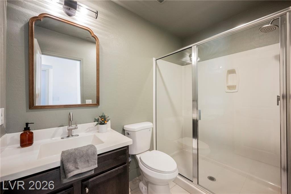 Downstairs bath with sage walls, framed mirror and walk-in shower at 2430 Quiet Ode Street
