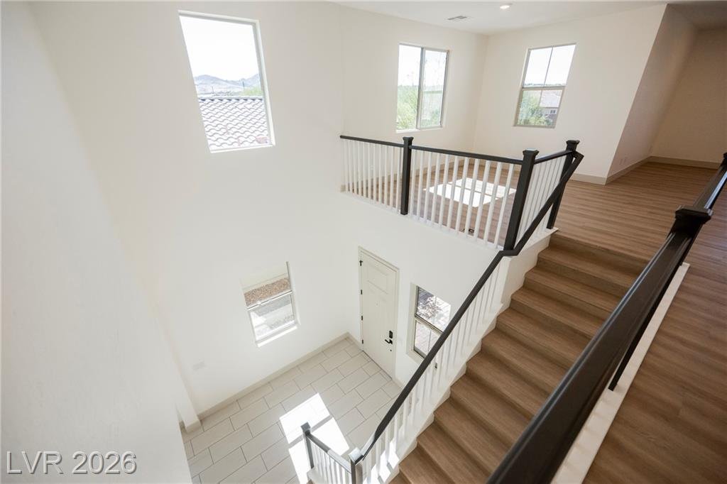 Wood staircase with black railing seen from the upstairs landing