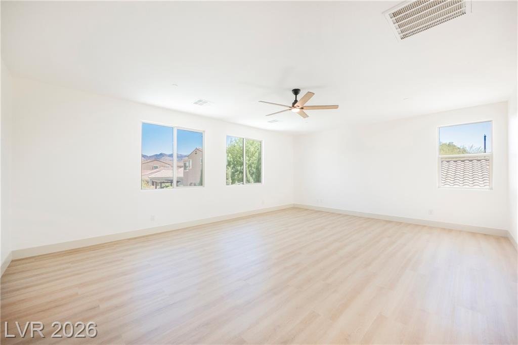 Primary bedroom with plank vinyl flooring, ceiling fan and mountain view