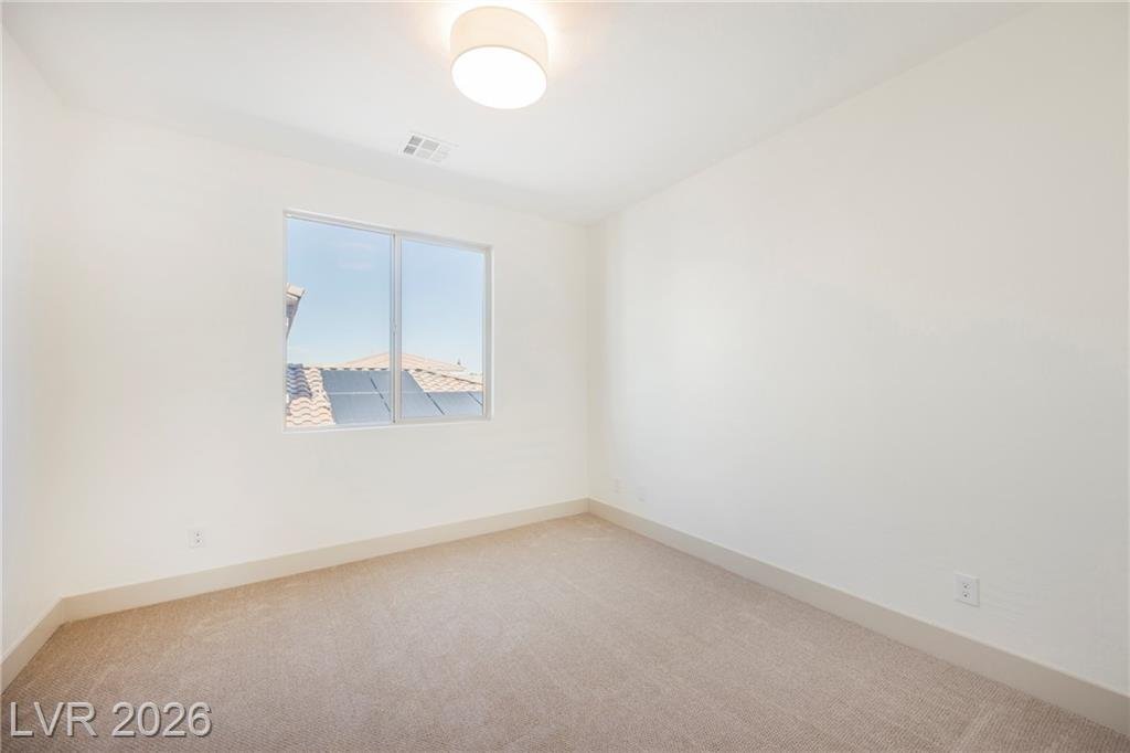 Upstairs bedroom with carpet and window toward the tile rooftops