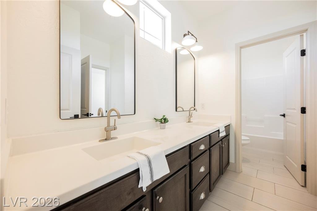 Upstairs bath with dual sinks and arched black mirrors