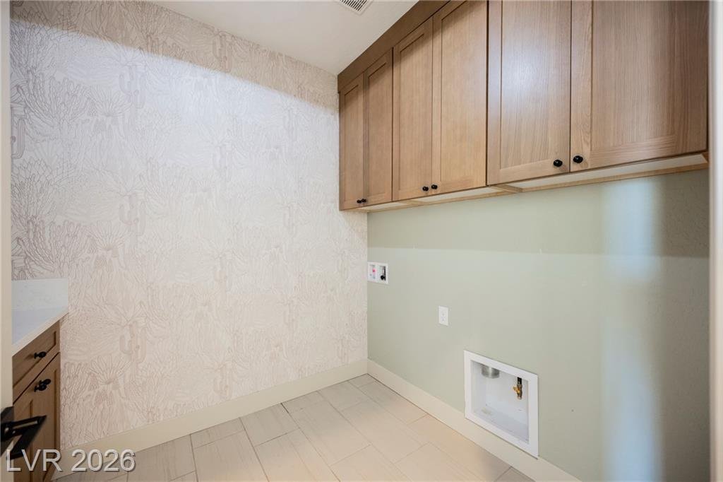 Laundry room with wood upper cabinets and botanical wallpaper