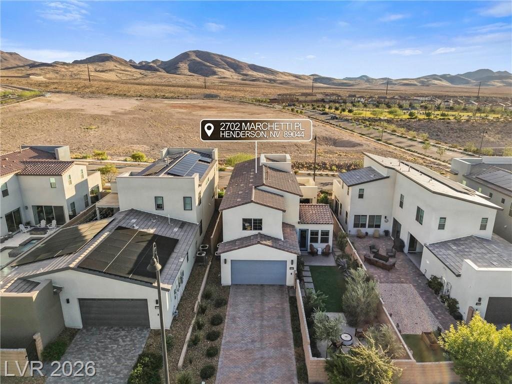 Aerial view of the home's paver driveway and side courtyard with the mountains behind