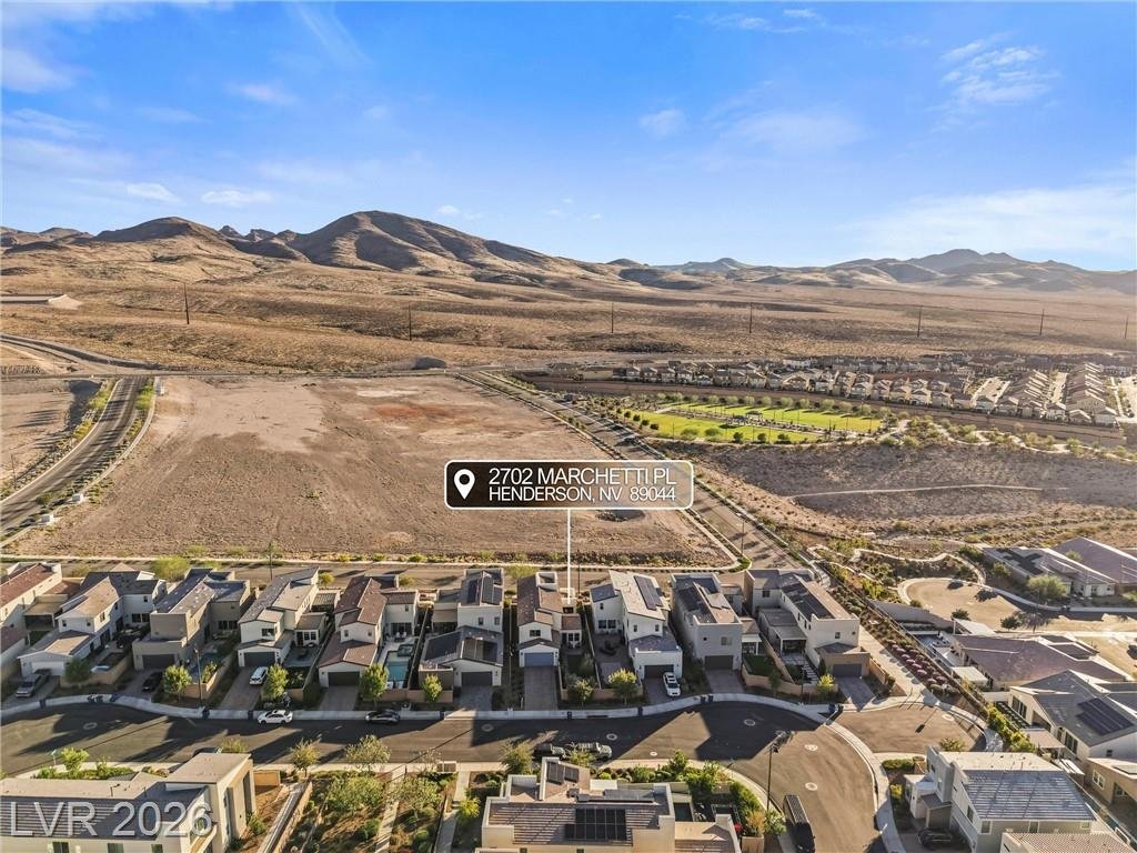 Aerial over the home toward open desert and mountains in Inspirada