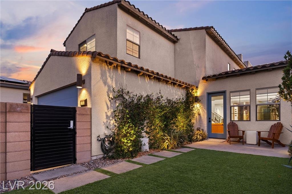 Side yard with synthetic turf, stepping pavers and a black slat gate