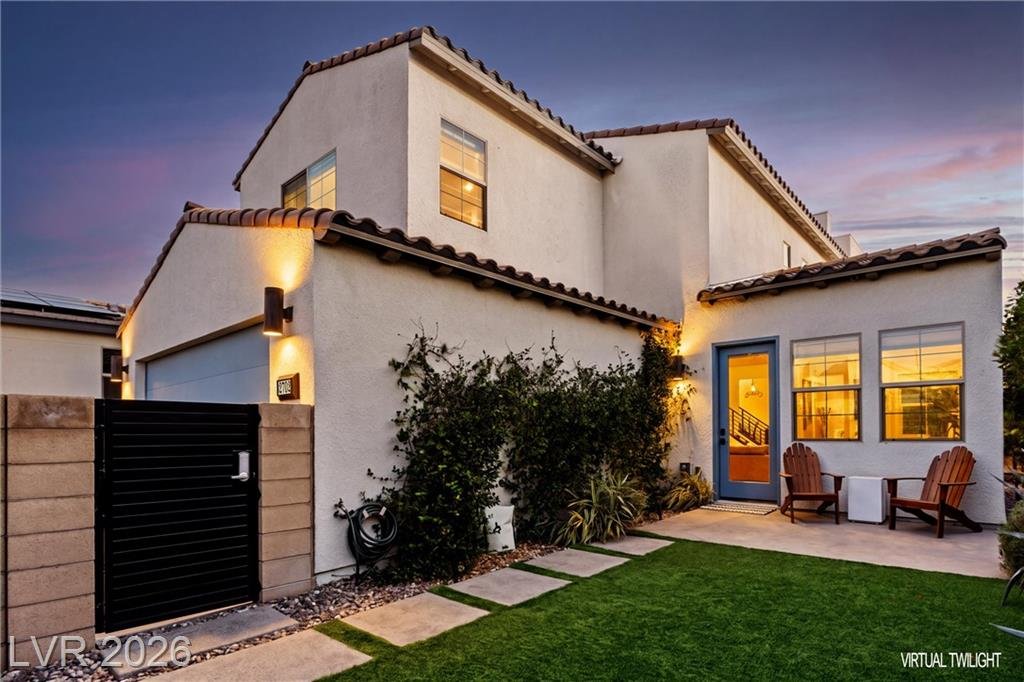 Side yard of 2702 Marchetti Place with turf and a lit patio, virtual twilight