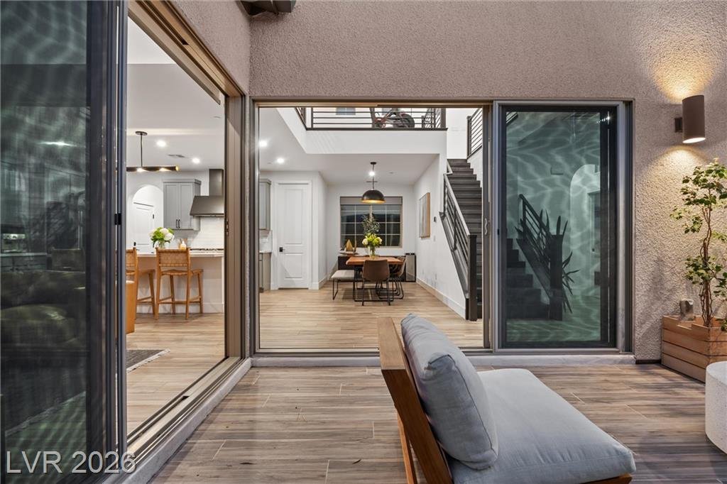 Sliding glass wall at 2702 Marchetti Place open from the courtyard to the kitchen and stairs