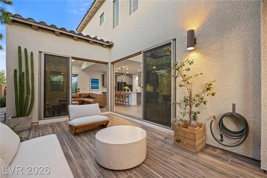 Wood-look tile courtyard at 2702 Marchetti Place with cactus planters and a wall sconce