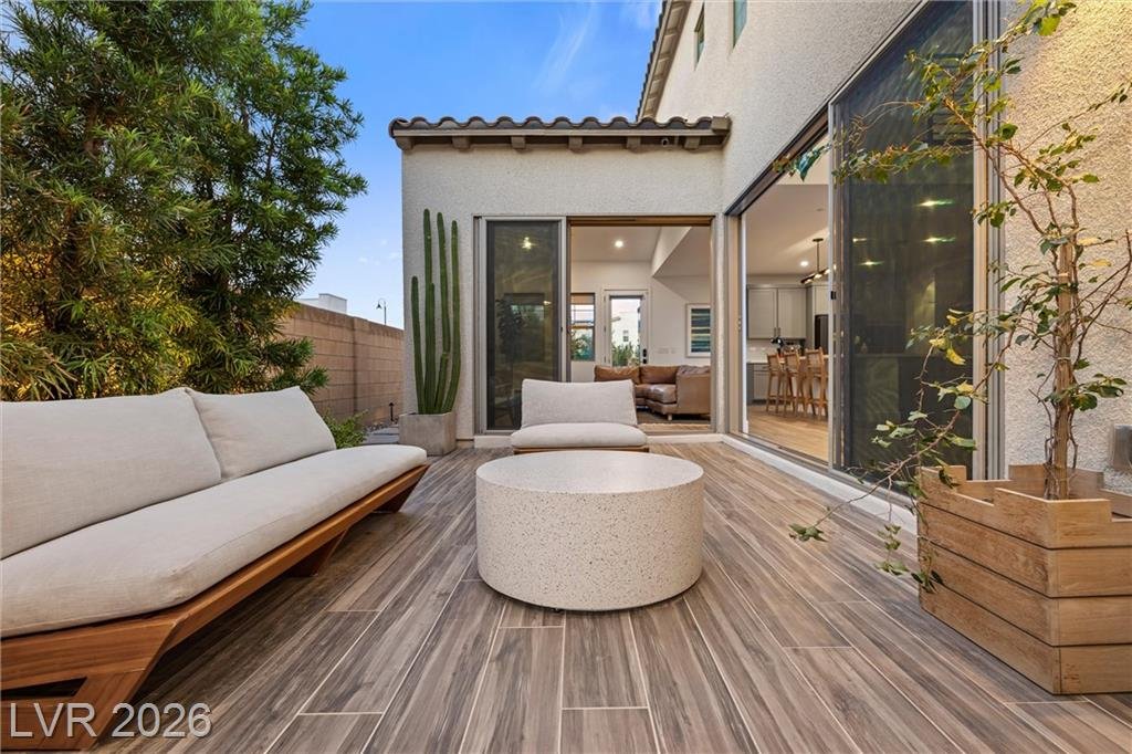 Built-in style courtyard sofa with a stone coffee table and shade trees