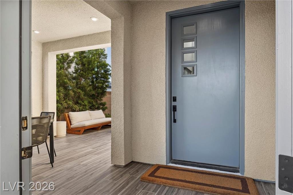 Blue-gray front door with glass lites off the covered front courtyard