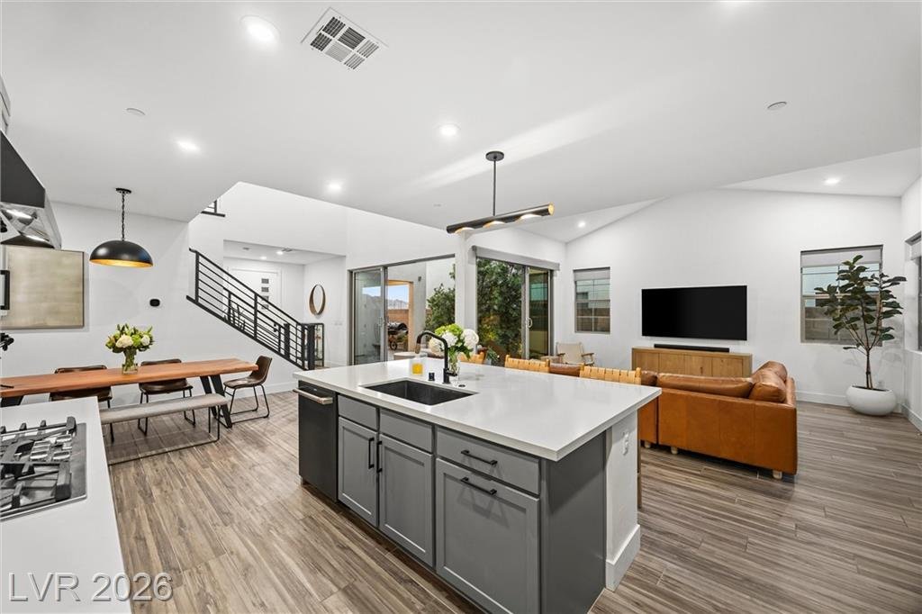 Kitchen island and five-burner gas cooktop under pendant lighting