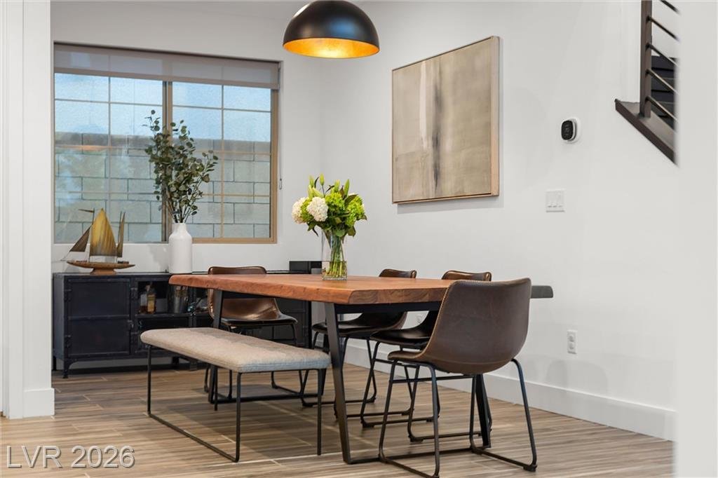 Dining room with a pendant light, bench seating and a wide window
