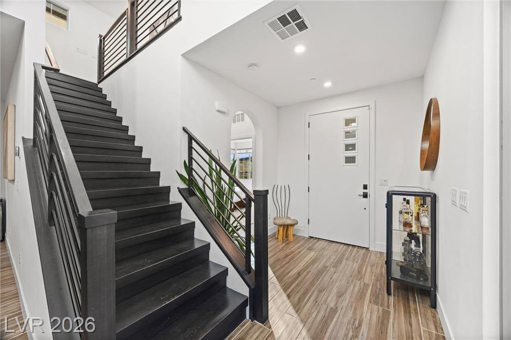Entry hall and wood staircase with modern black railing at 2702 Marchetti Place