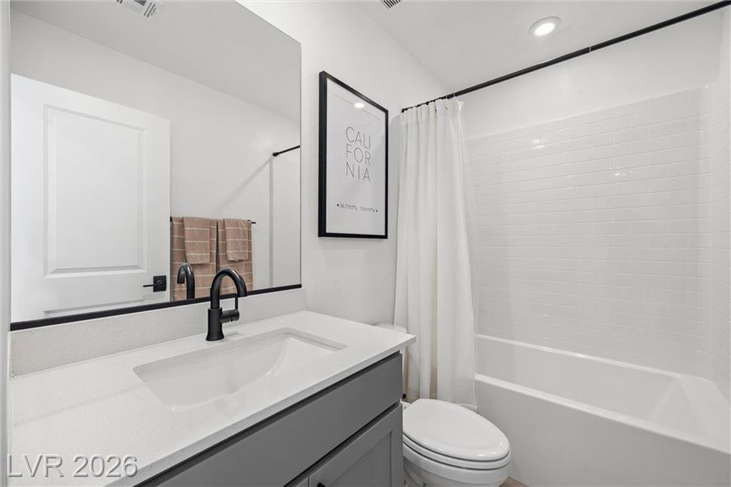 Upstairs hall bath with a gray vanity and tub-shower
