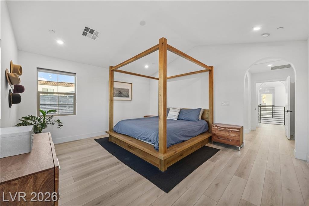 Primary bedroom at 2702 Marchetti Place with a vaulted ceiling and arched doorway
