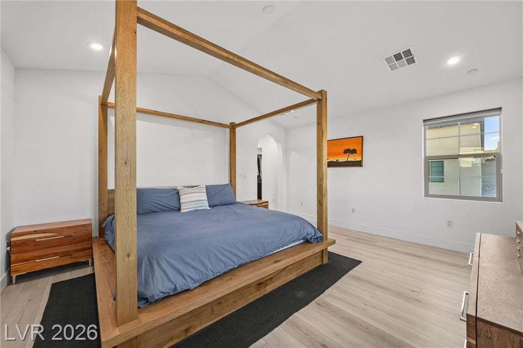 Primary bedroom canopy bed between two windows