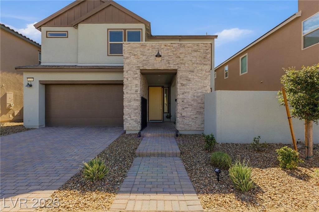 Paver driveway and walkway leading to the stone-faced front entry