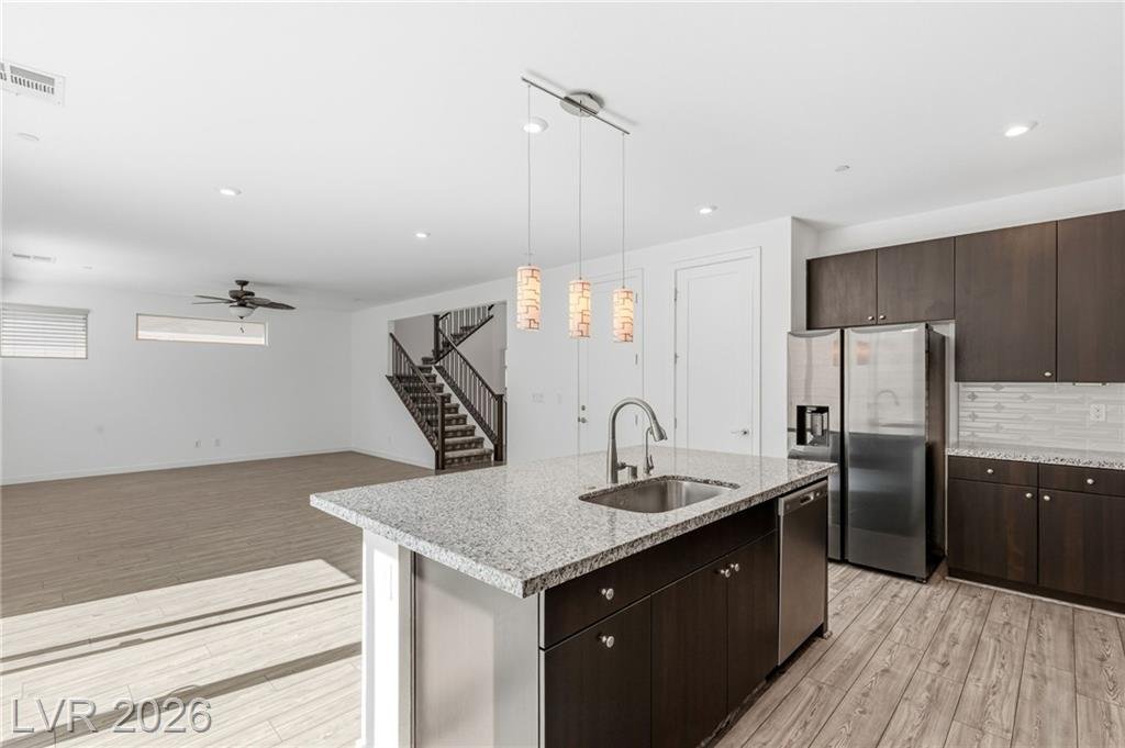 Granite island with undermount sink, dishwasher and stainless refrigerator
