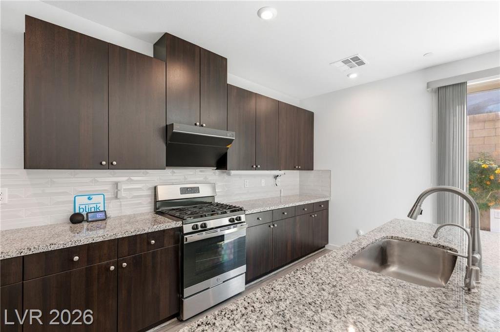 Kitchen sink wall with granite counters and espresso cabinetry at 3233 Waterstone Avenue