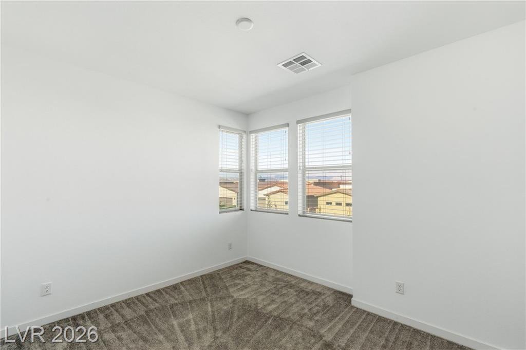 Second bedroom with corner windows and carpet
