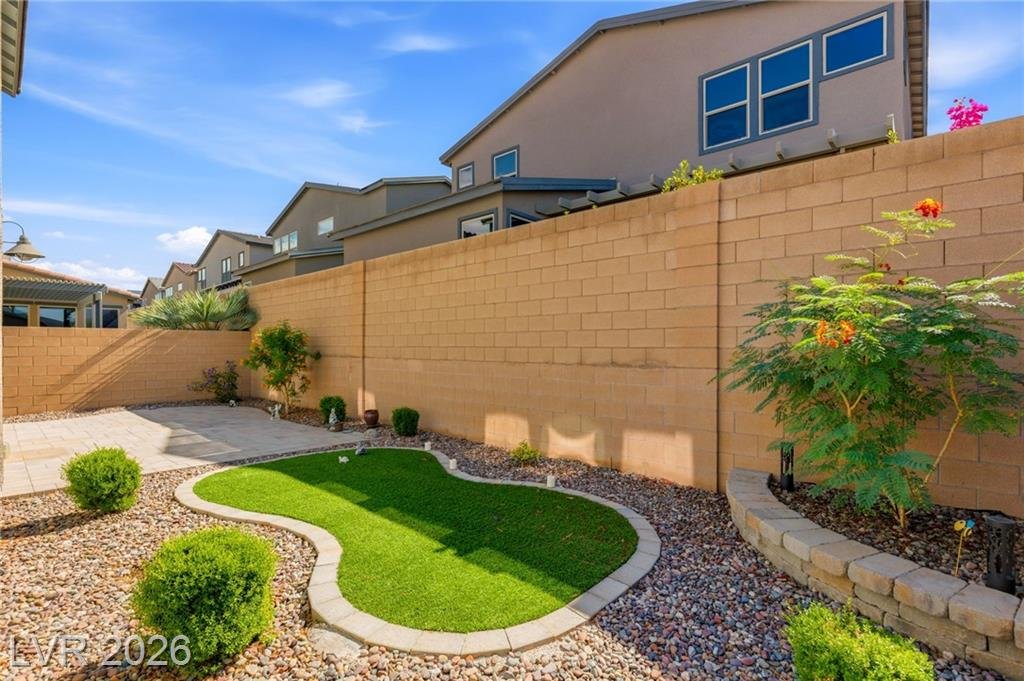 Backyard with curved synthetic turf, raised planters and desert landscaping in Inspirada