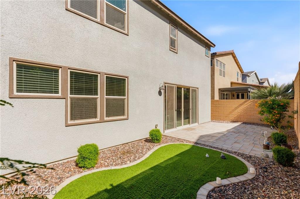 Rear of 3233 Waterstone Avenue showing the sliding door and turf lawn