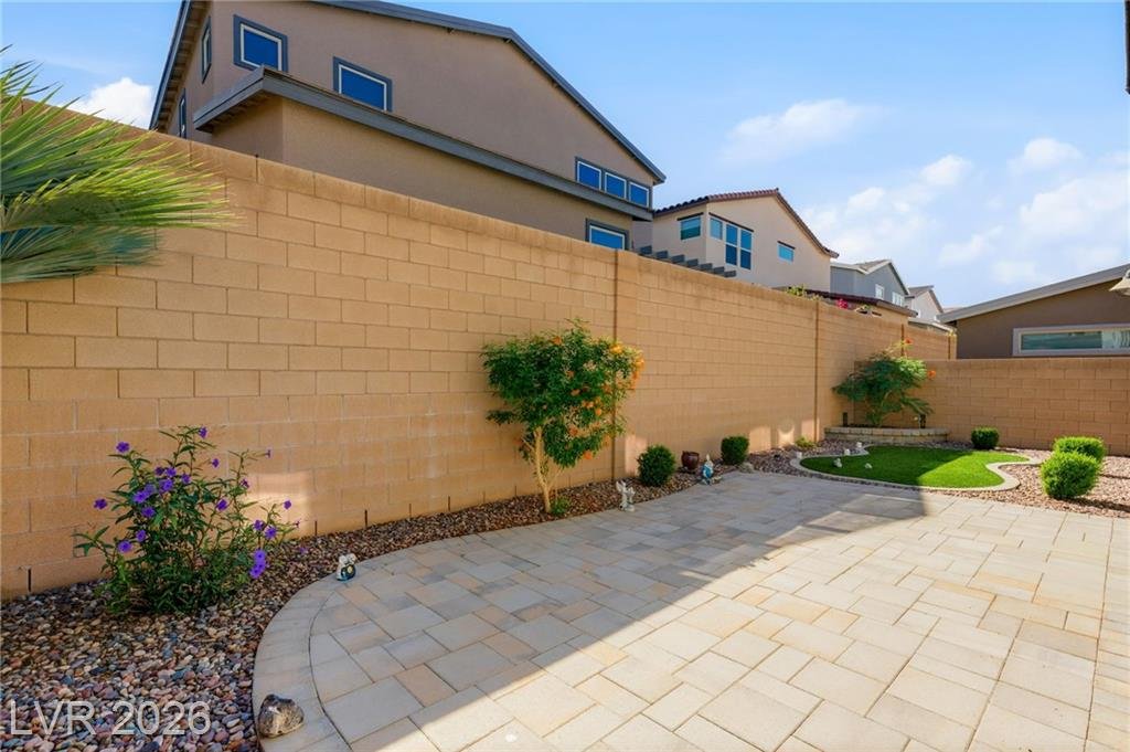 Backyard paver patio with block wall and flowering shrubs in Inspirada, Henderson