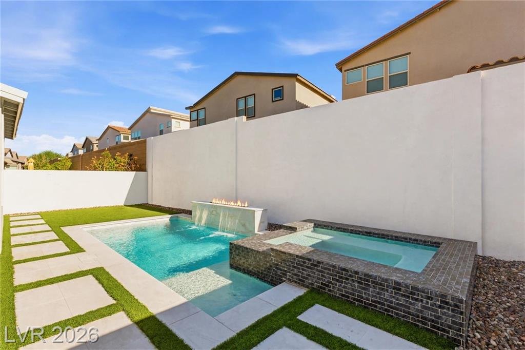 Tiled spa spilling into the pool with a linear fire feature at 3263 Fountaintree Avenue