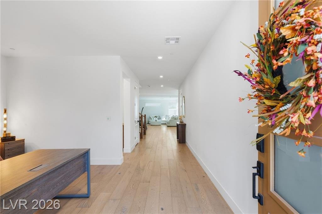 Entry hall with wide-plank hardwood floors looking back toward the great room