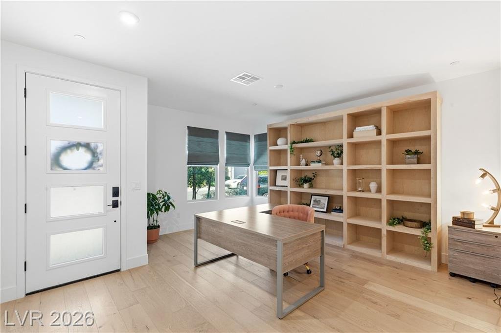 Den with a full wall of built-in bookcase shelving beside the front door at 3263 Fountaintree Avenue