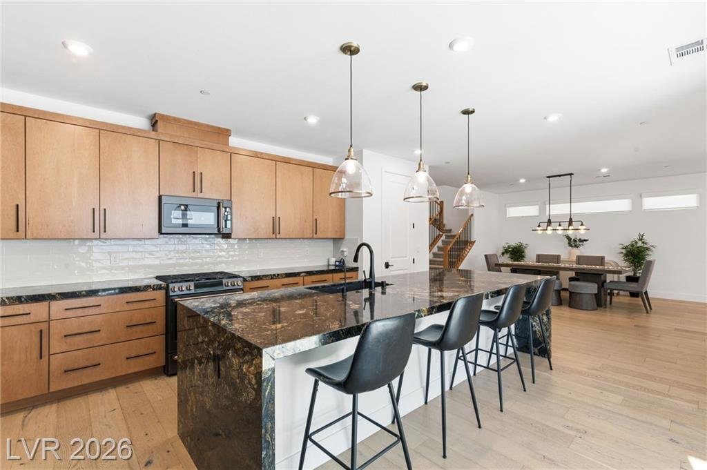 Extended granite island with bar seating looking toward the dining area at 3263 Fountaintree Avenue