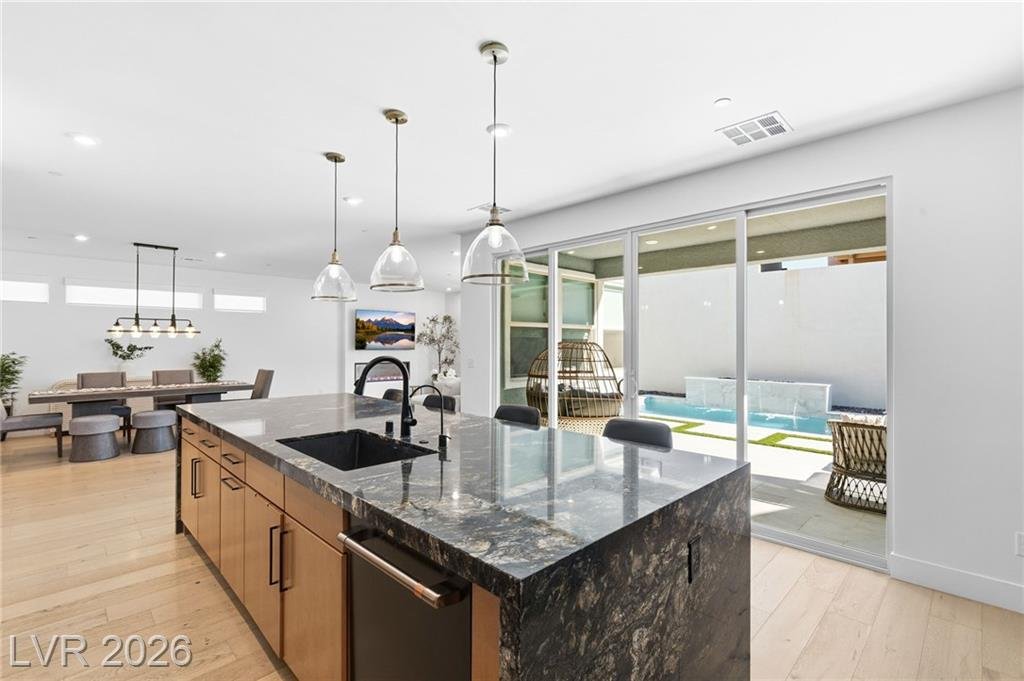 Island sink with matte black faucet facing the pool view at 3263 Fountaintree Avenue