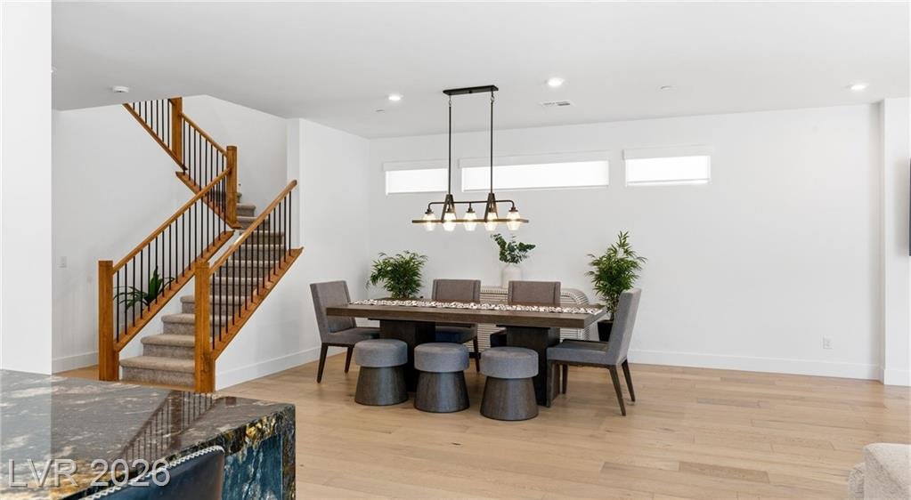 Dining area beside the wood-rail staircase with clerestory windows
