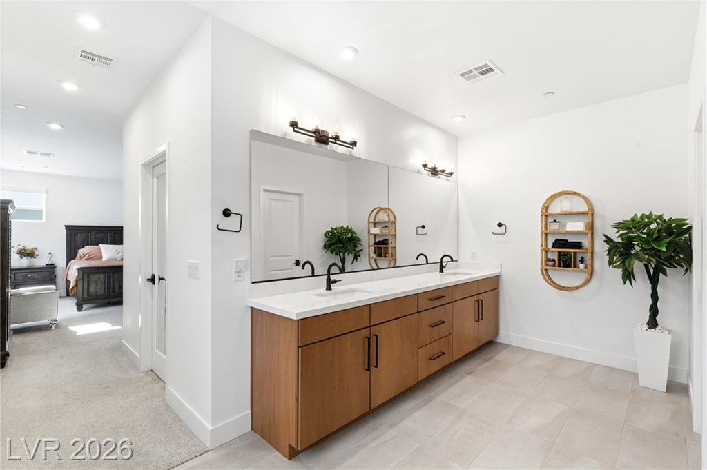 Primary bath double vanity with quartz top looking back to the bedroom