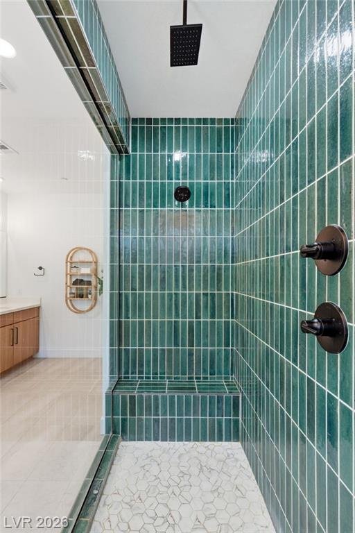 Rain shower head and matte black valves against vertical emerald tile