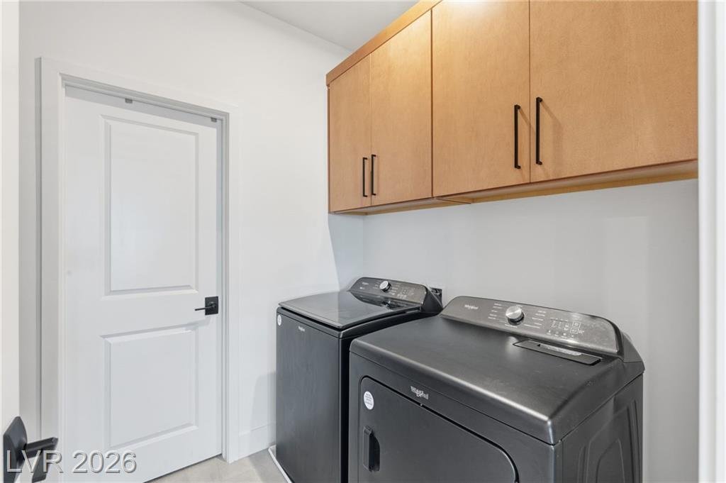 Laundry room with upper cabinets, connected to the primary closet at 3263 Fountaintree Avenue