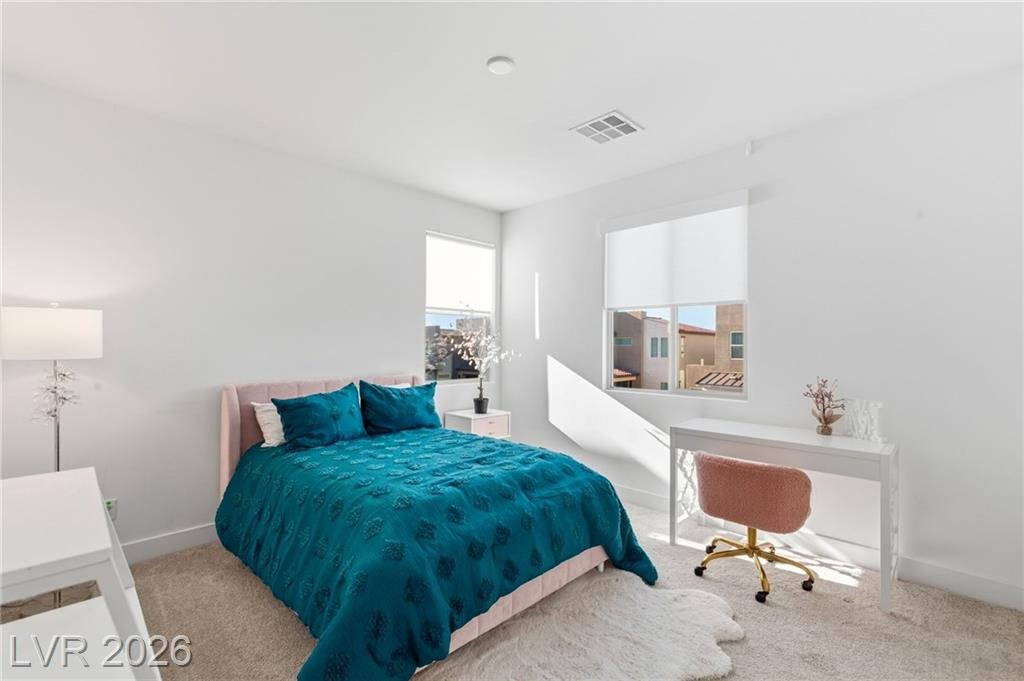 Secondary bedroom with two windows and space for a desk