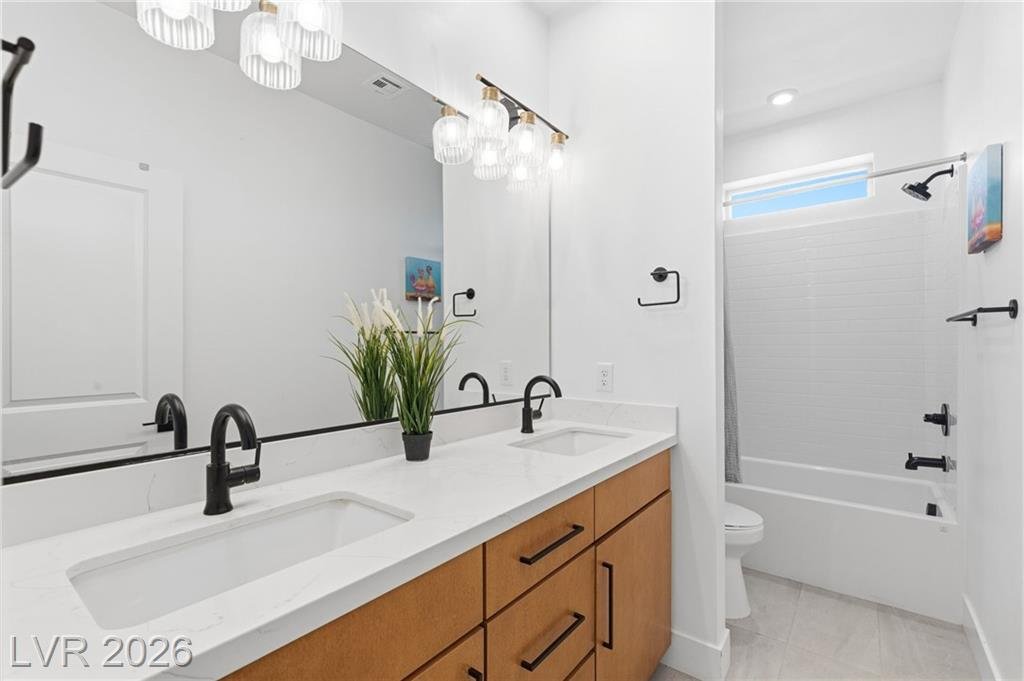 Hall bath with double sinks and a tub-shower combination