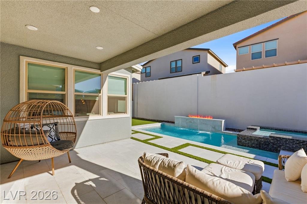 Covered patio with stone tile looking out to the pool and fire feature at 3263 Fountaintree Avenue