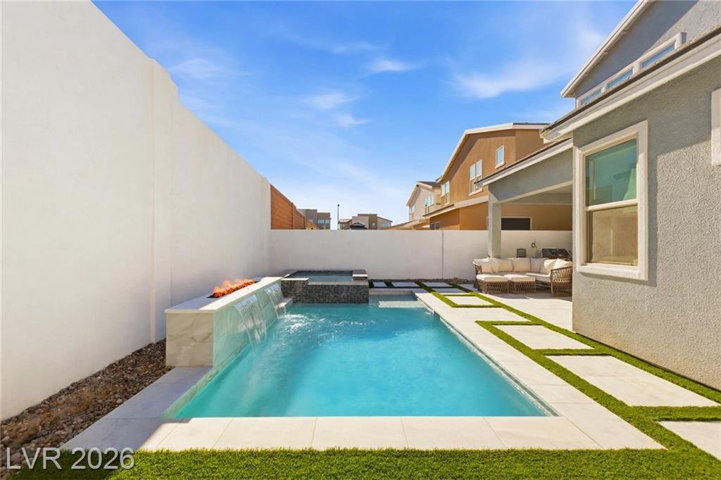 Pool with spillway and fire bowls along the block wall