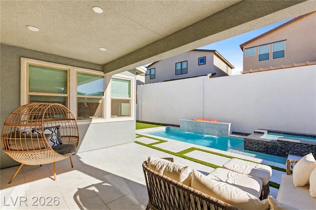 Shaded patio seating beside the pool and spa