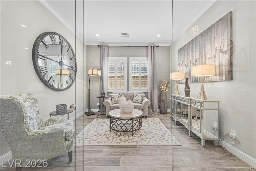 Glass office seating area with a wall clock and mirrored console