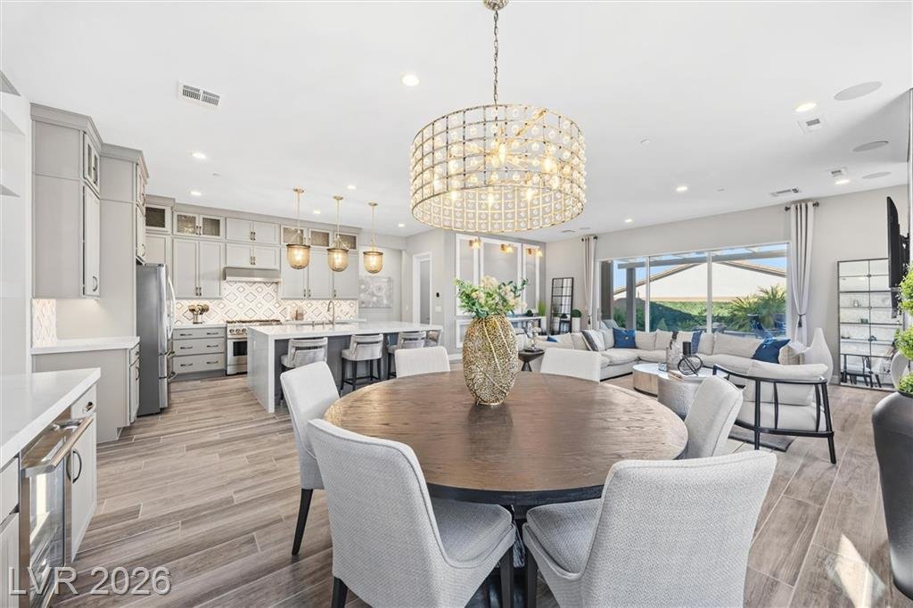 Round dining table under a crystal drum chandelier