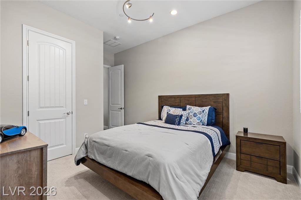 Third bedroom with carpet and a track light
