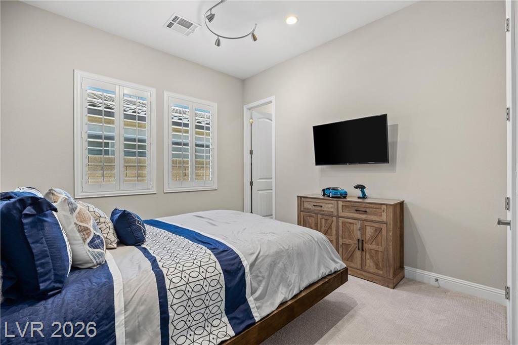Third bedroom with shuttered windows and a wall-mounted TV