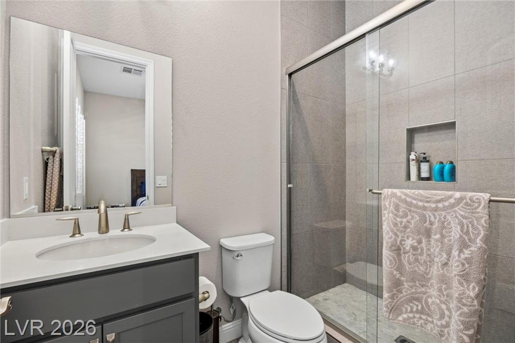 Hall bath with a glass walk-in shower and gold fixtures