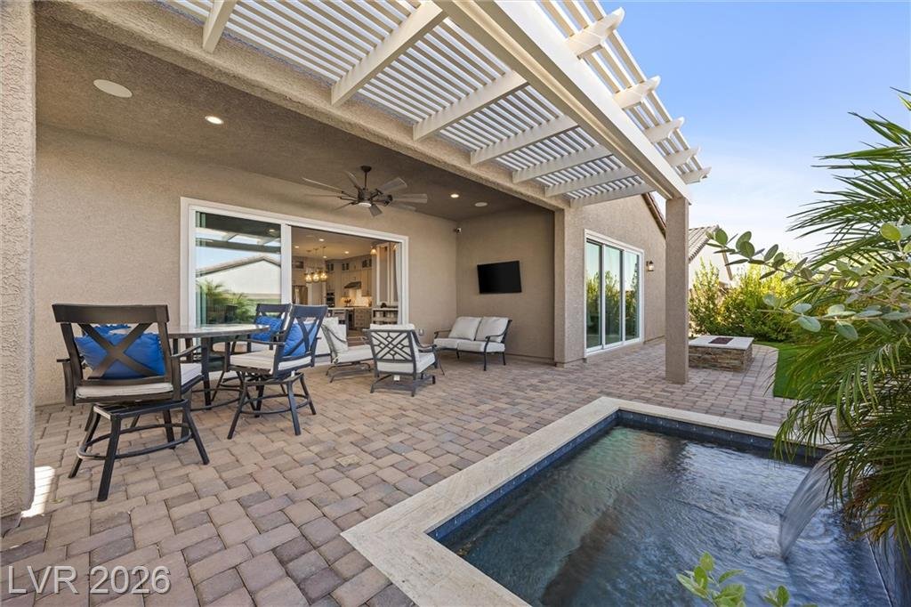 Covered patio with ceiling fan beside the spa