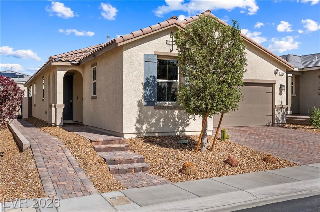 Front of 3500 Brezine Avenue with blue shutters, an arched entry and desert landscaping